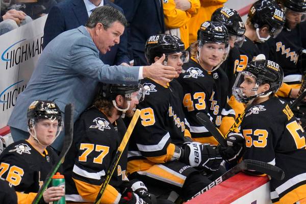 Pittsburgh Penguins coach Mike Sullivan, left, gives instructions to Teddy Blueger (53) during ...