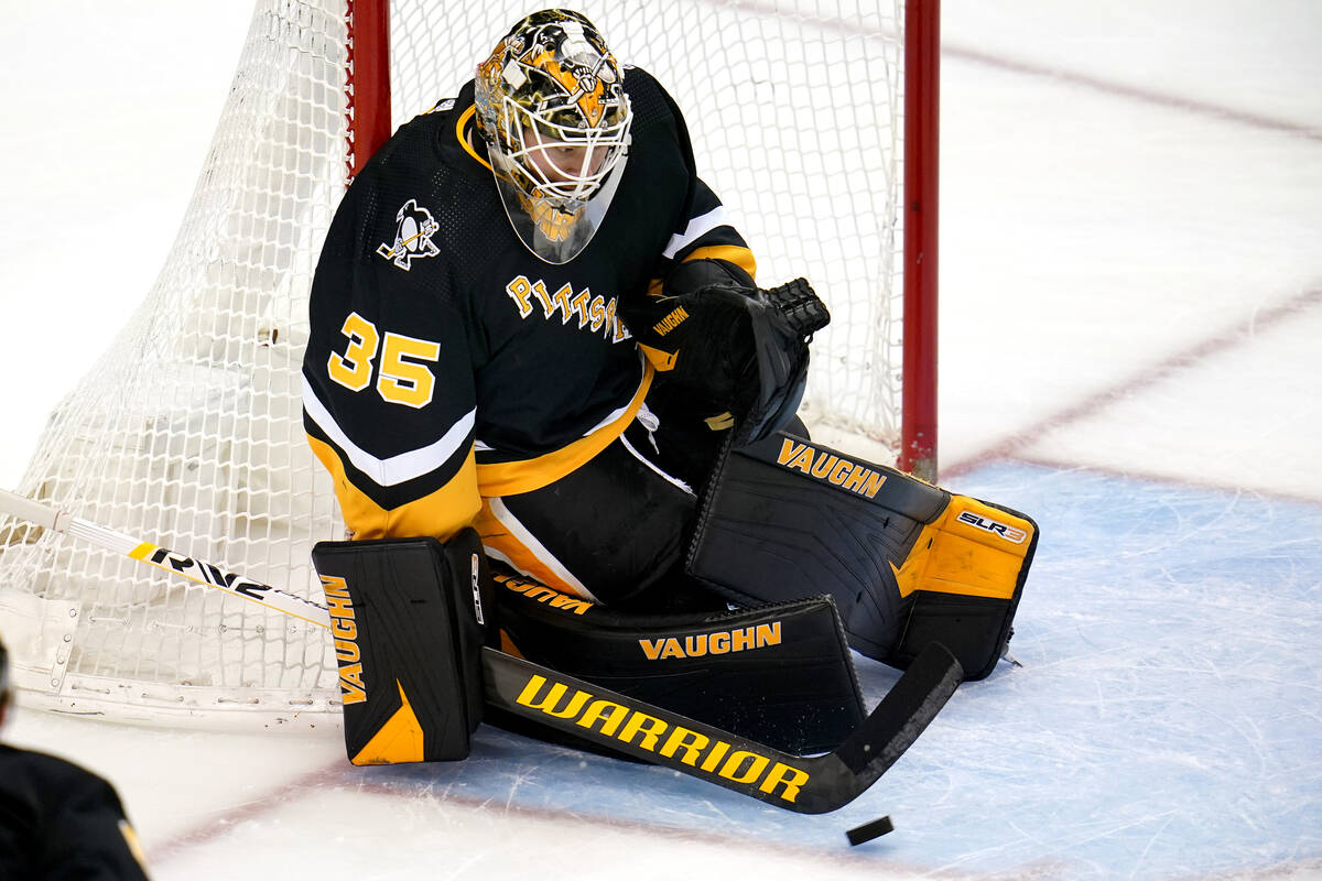Pittsburgh Penguins goaltender Tristan Jarry stops a shot during the first period of an NHL hoc ...
