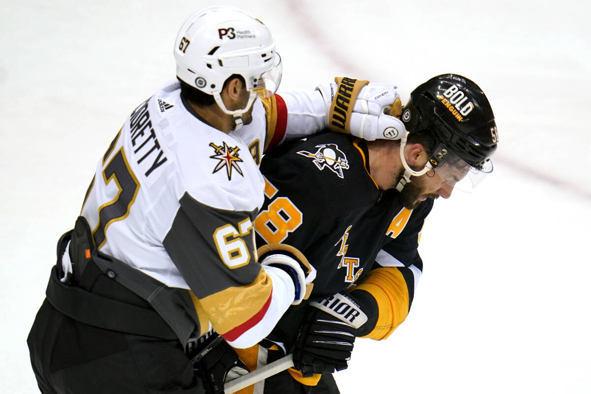 Vegas Golden Knights' Max Pacioretty (67) punches Pittsburgh Penguins' Kris Letang during the f ...