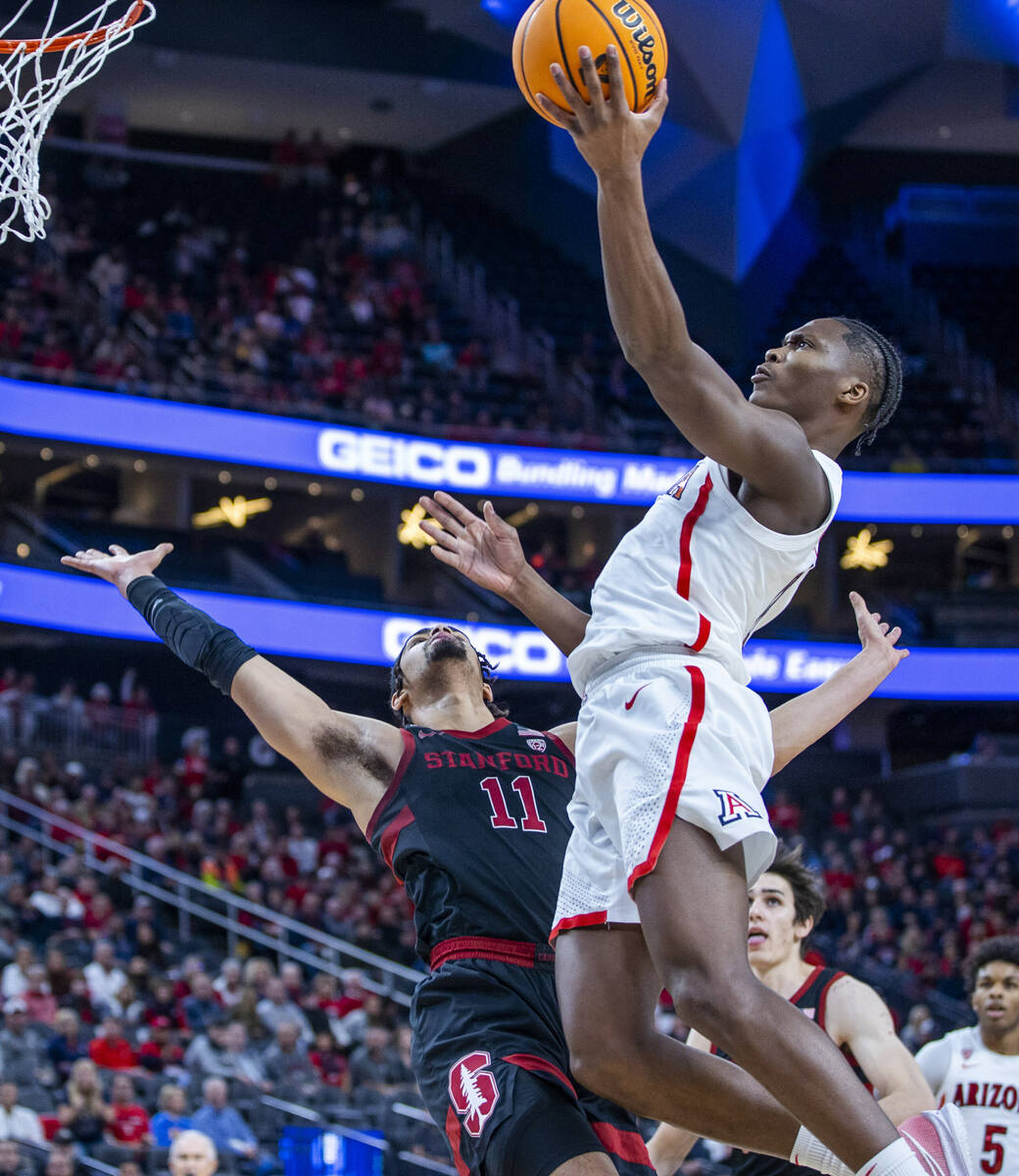 Arizona Wildcats guard Bennedict Mathurin (0) readies to lay the ball in after hard contact wit ...