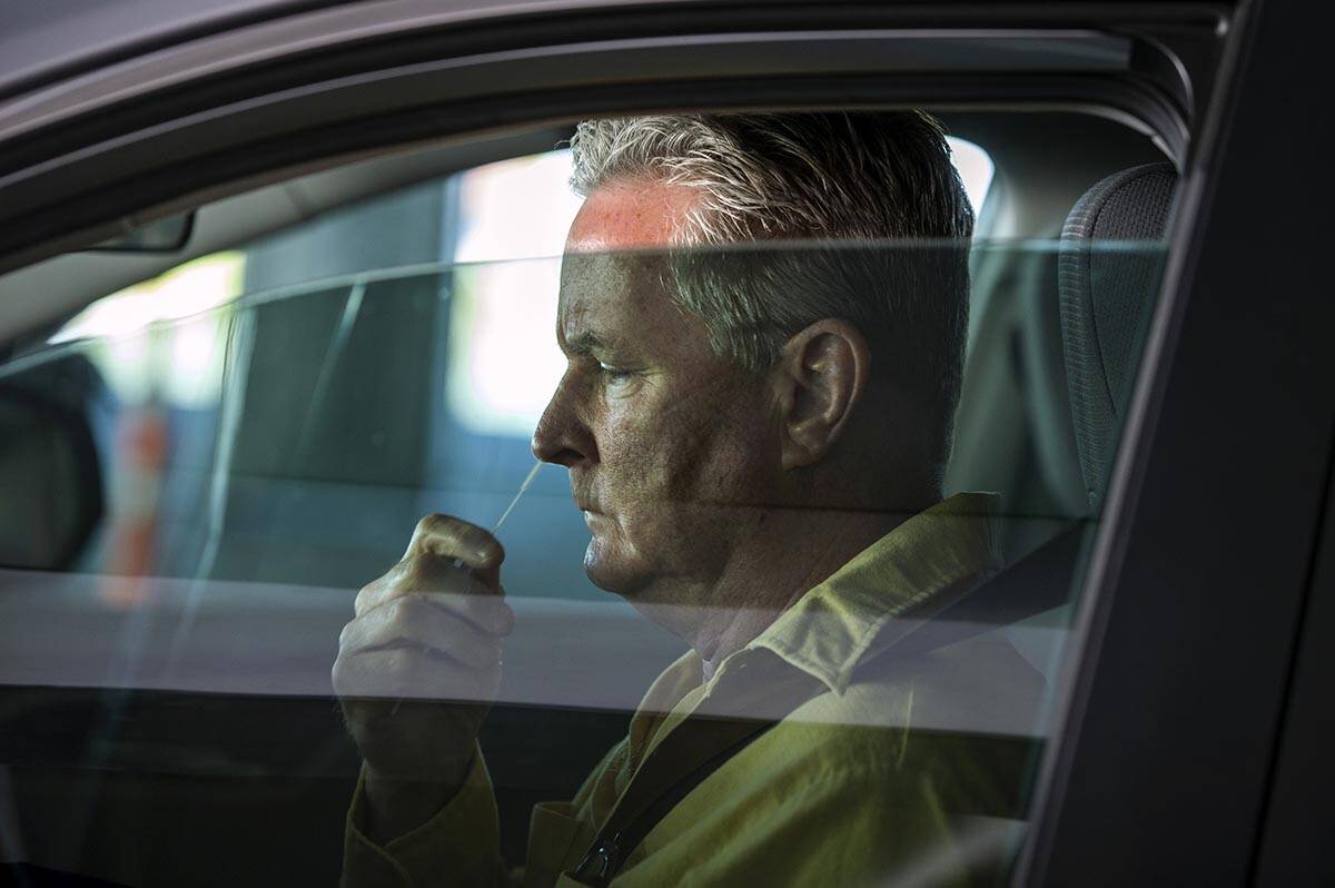 Tom Griffin uses a swab while self-administering a COVID-19 test as the Southern Nevada Health ...