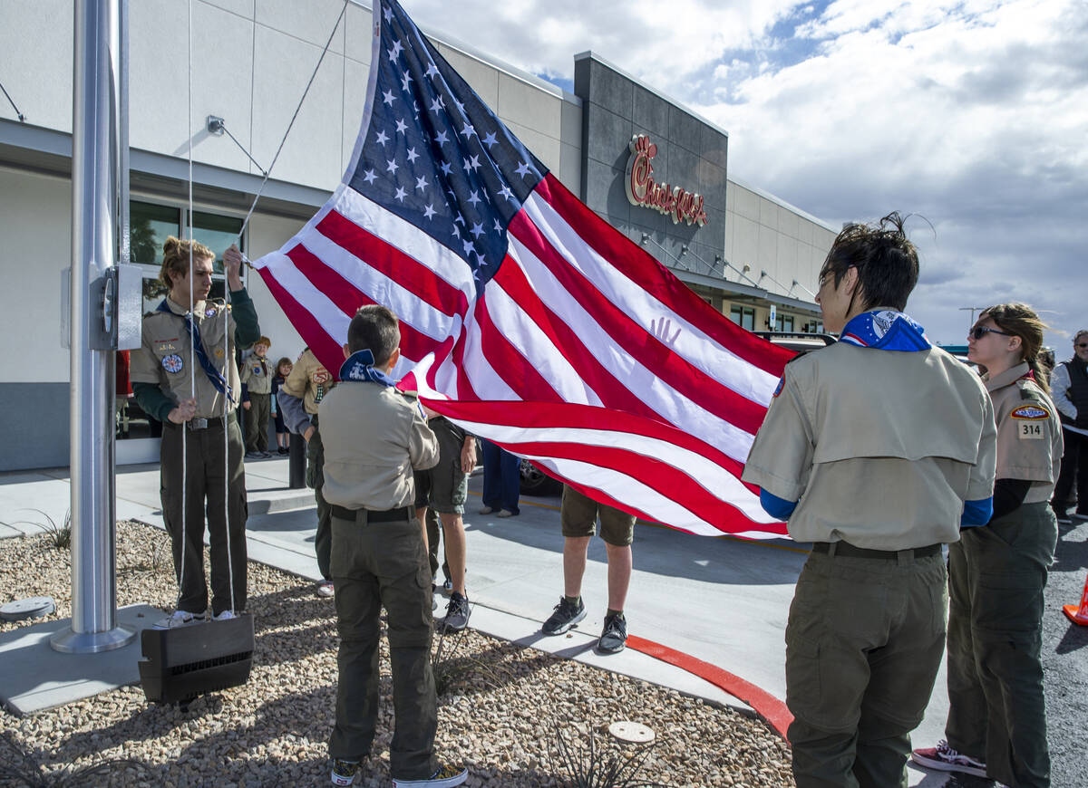Boy Scout Troop 314 members raise an American flag as the new Chick-Fil-A opens complete with a ...