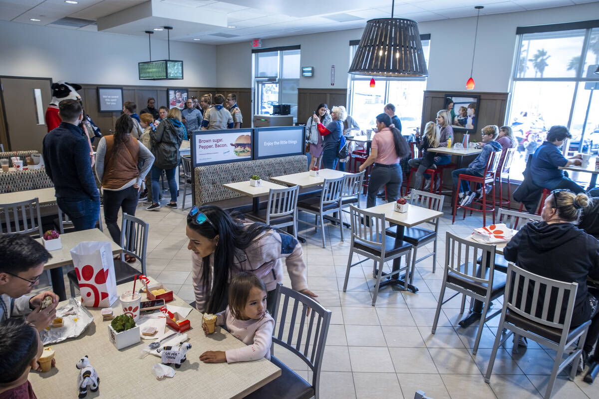 Customers have a bite in the dining room as the new Chick-Fil-A opens complete with a ribbon cu ...