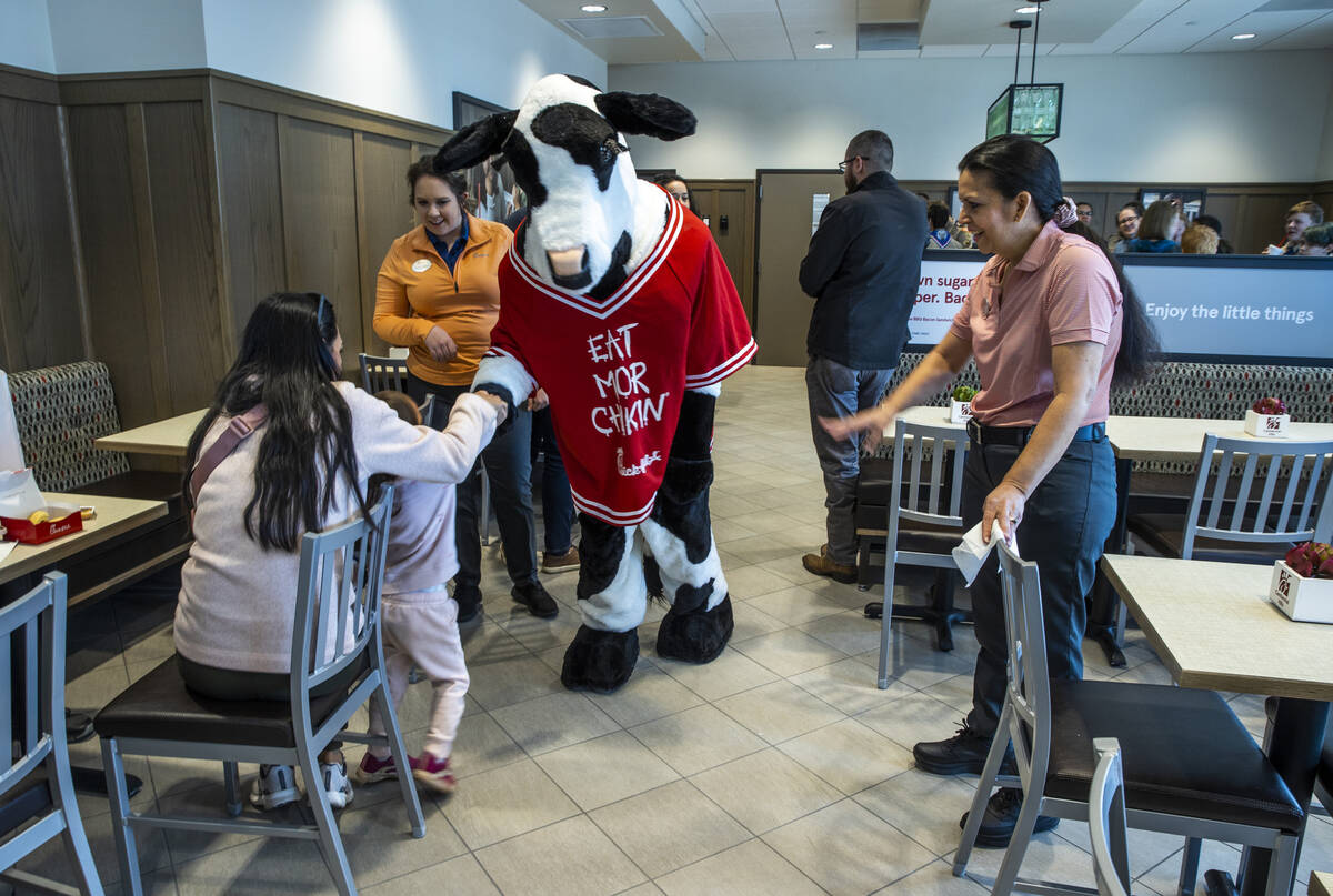 The Chick-Fil-A cow greets customers as the store opens complete with a ribbon cutting ceremony ...