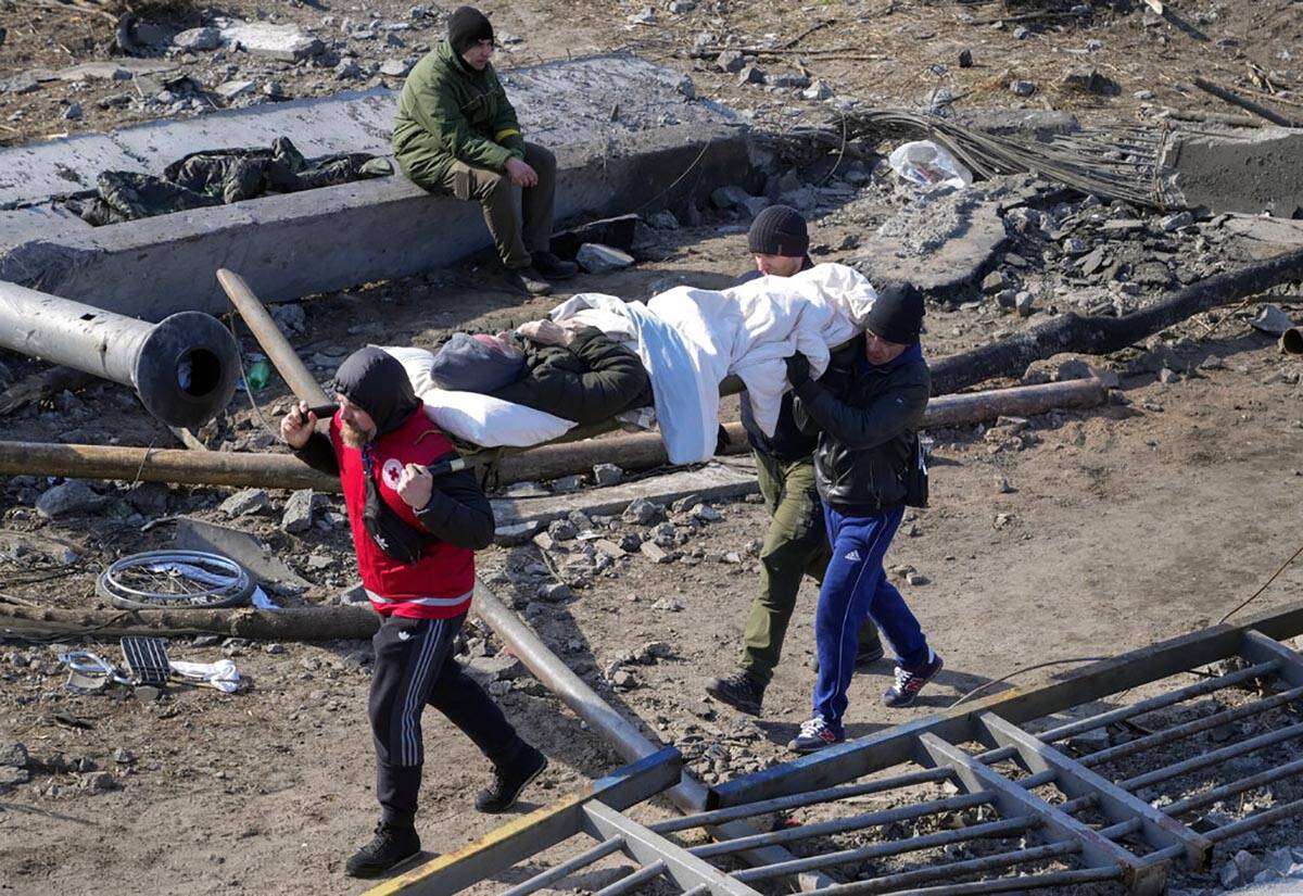 Volunteers evacuate an elderly resident in Irpin, some 25 km (16 miles) northwest of Kyiv, Frid ...