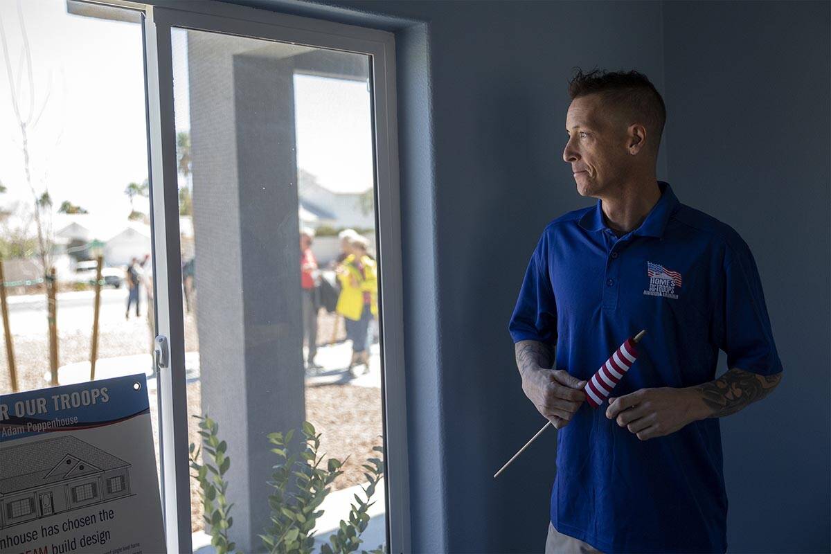 Sgt. Adam Poppenhouse, who was injured in Iraq in 2006, looks out the window of his new home d ...