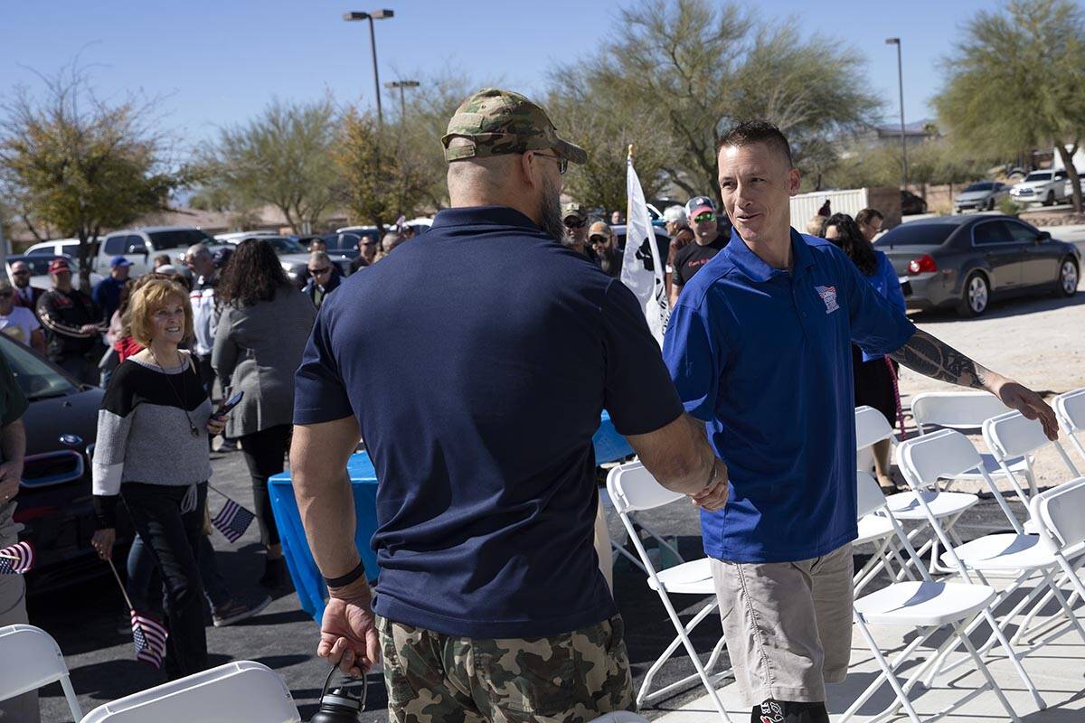 Army Sergeant Adam Poppenhouse shakes hands with a fellow injured veteran during the Homes for ...
