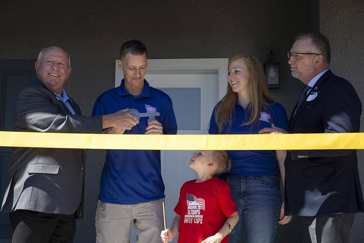 Homes For Our Troops CEO Tom Landwermeyer, left, presents Army Sergeant Adam Poppenhouse the ke ...
