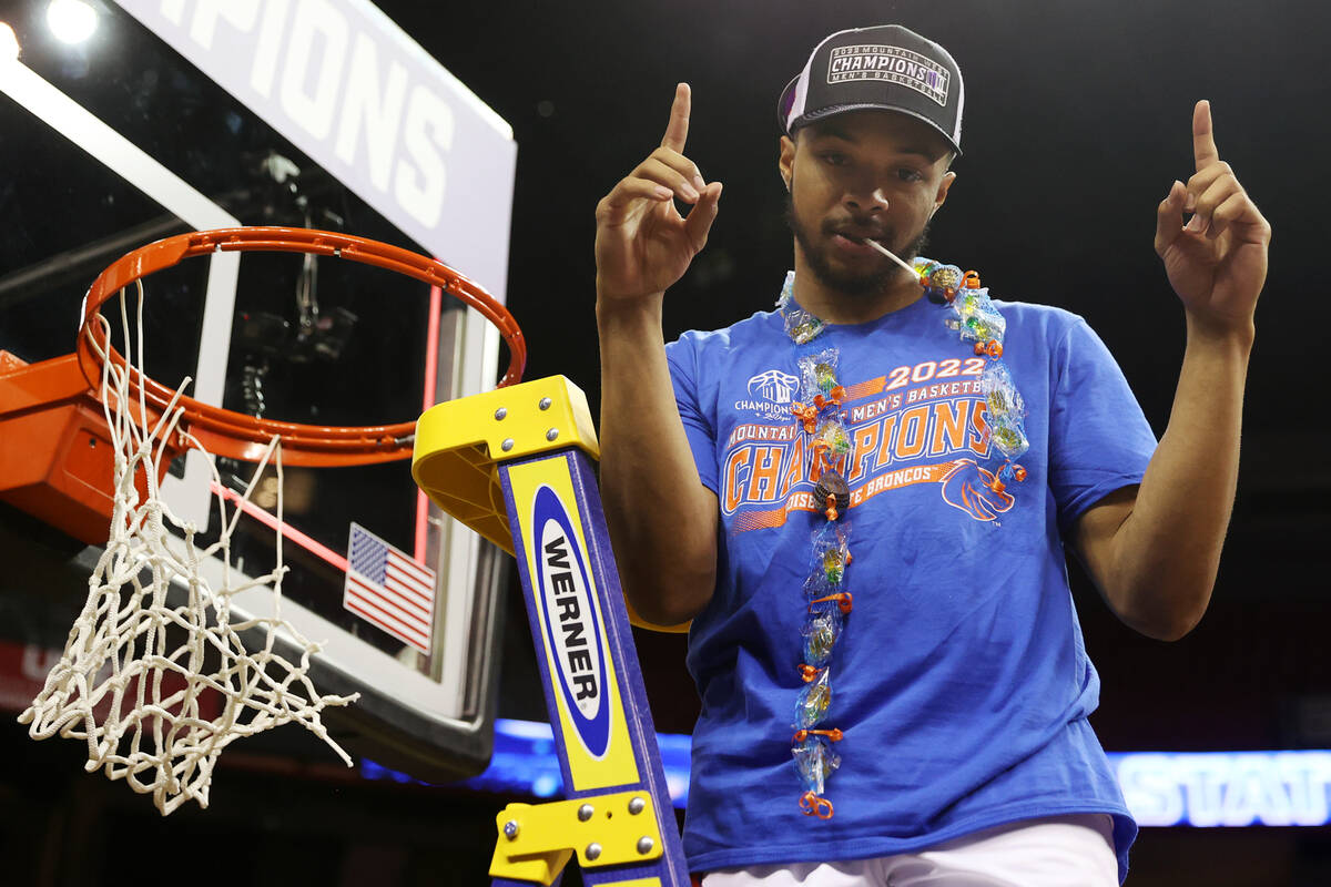 Boise State Broncos guard Marcus Shaver Jr. (10) poses with a piece of the net after defeating ...