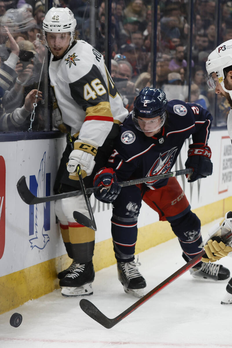 Vegas Golden Knights' Jonas Rondbjerg, left, and Columbus Blue Jackets' Andrew Peeke fight for ...