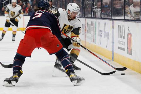 Vegas Golden Knights' William Carrier, right, controls the puck as Columbus Blue Jackets' Andre ...