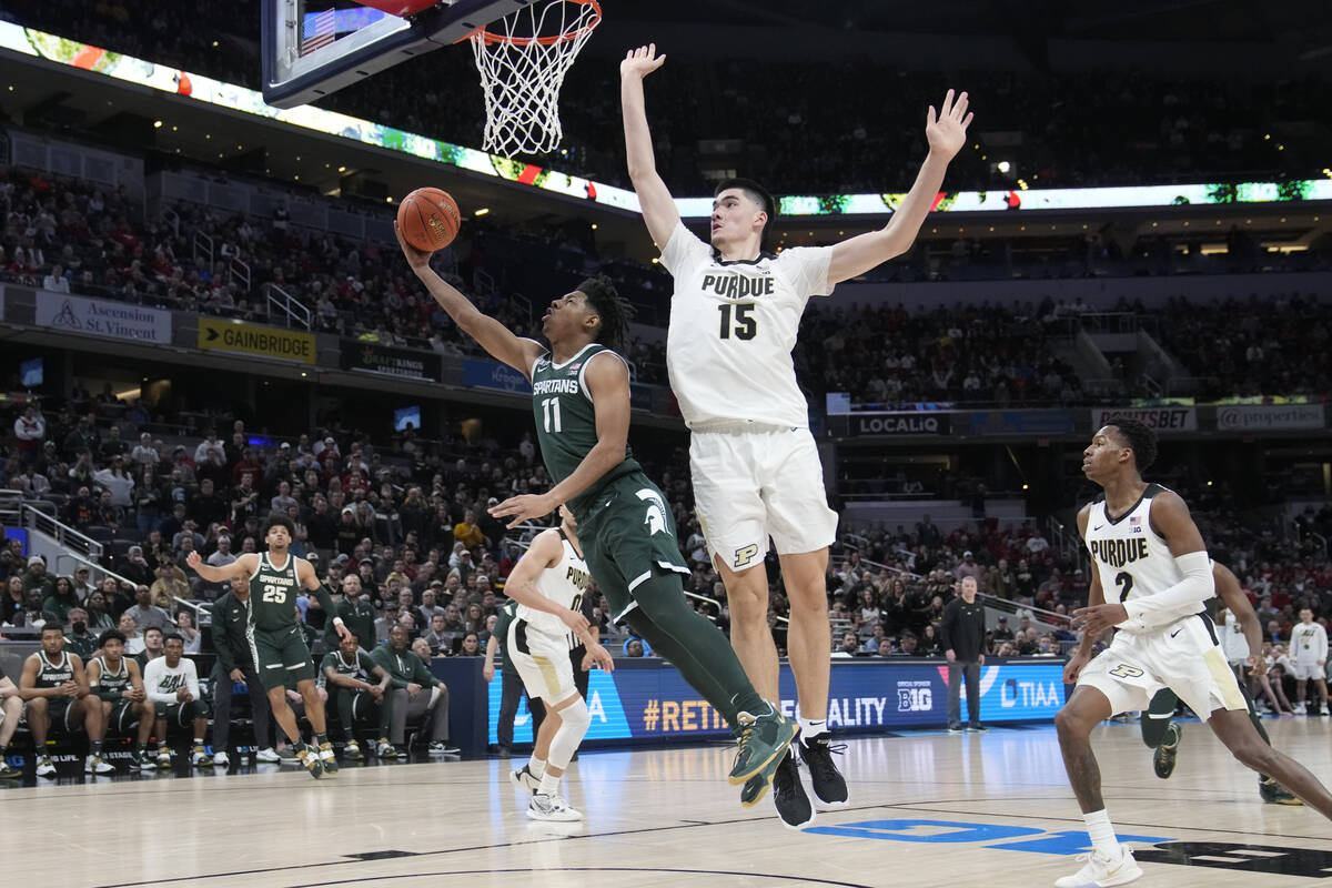 Michigan State guard A.J. Hoggard (11) puts up a shot against Purdue center Zach Edey (15) duri ...