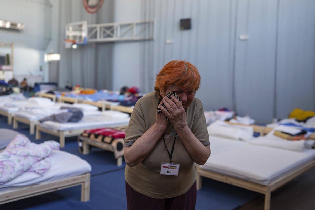 Zinaida Pivtsova, 75, who fled the war in Ukraine, wipes tears inside a sports stadium of a hig ...