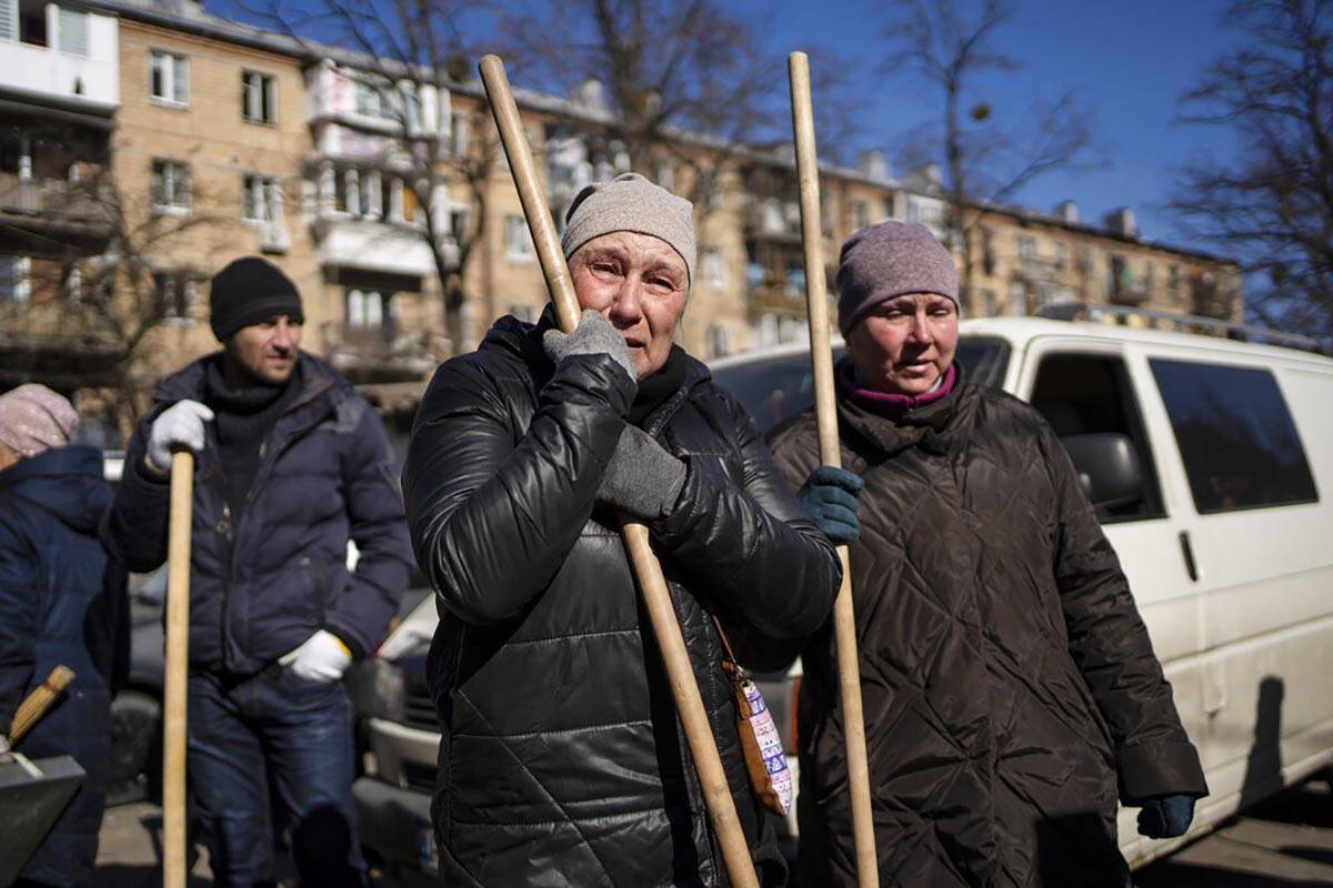 A woman cries before starting to clean the site where a bombing damaged residential buildings i ...