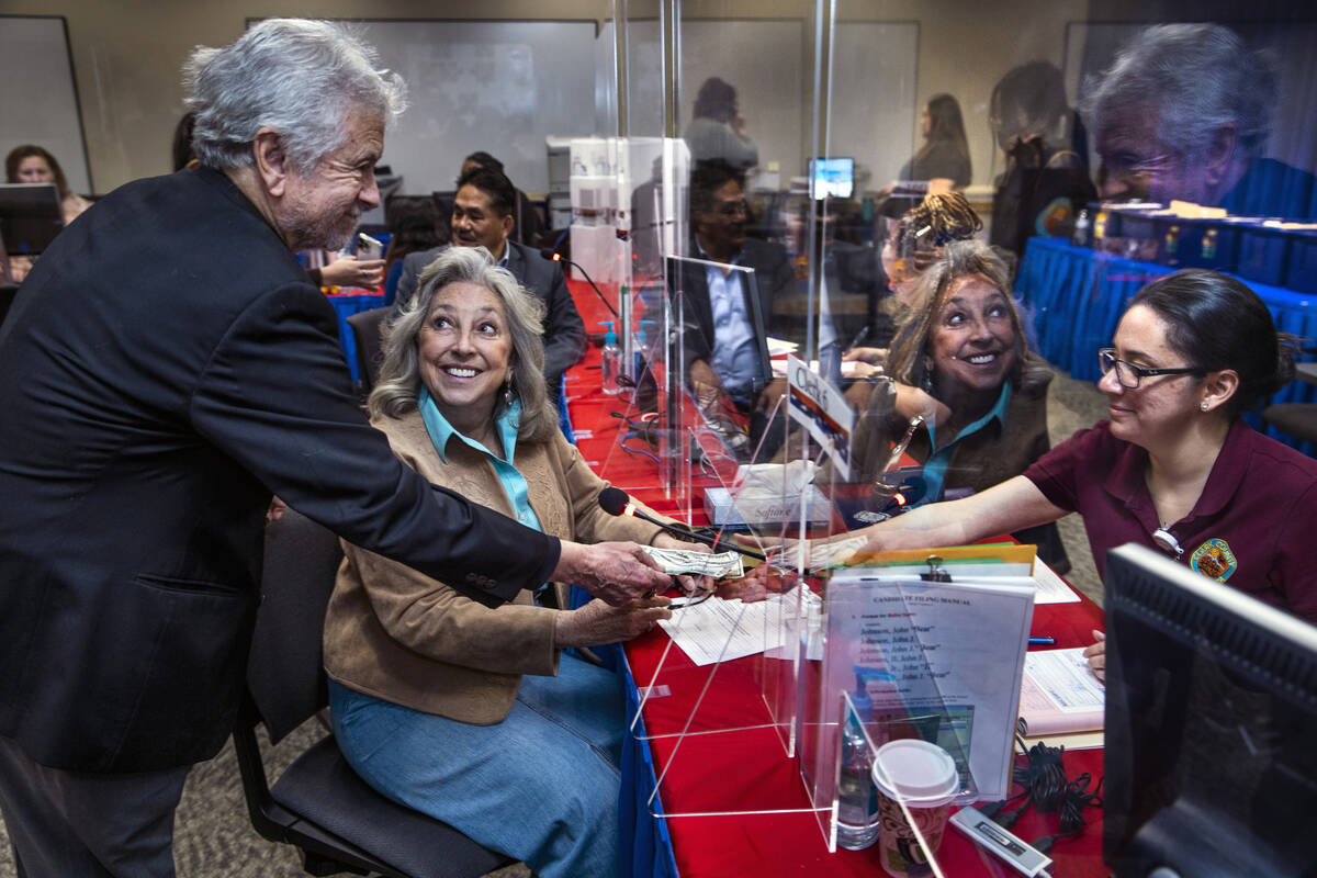 Former Las Vegas City Councilman Bob Coffin, from left, hands over some cash as Rep. Dina Titus ...