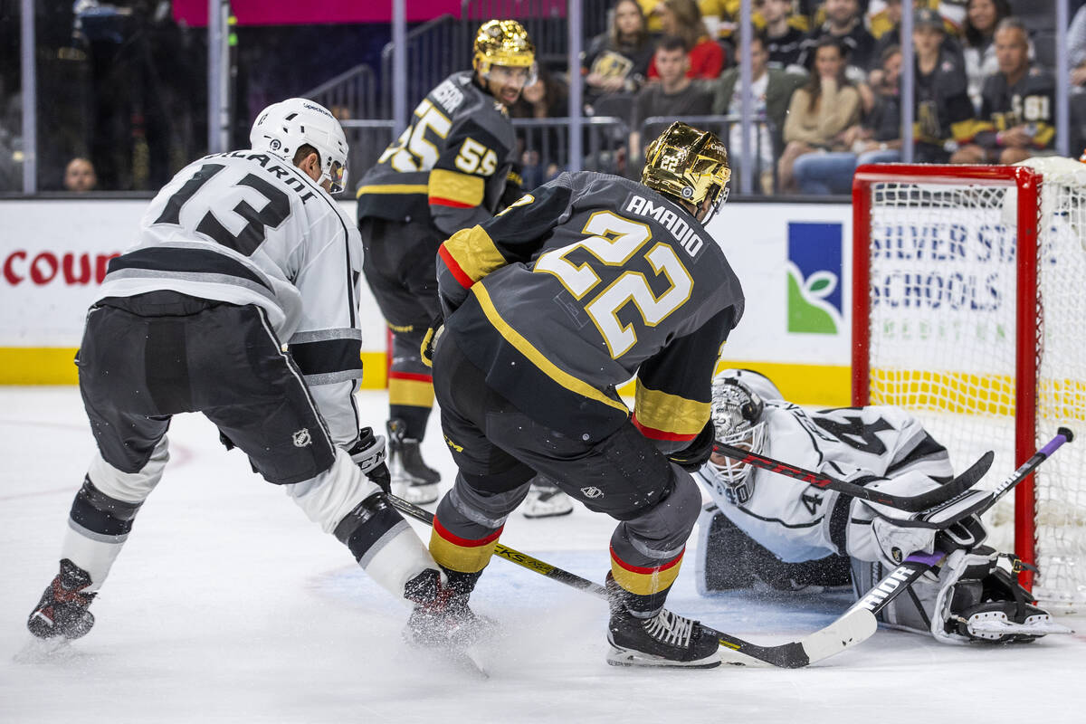 Golden Knights center Michael Amadio (22) slides the puck beneath Los Angeles Kings goaltender ...