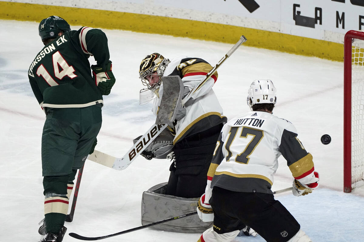 Vegas Golden Knights goalie Logan Thompson, center, deflects a shot by Minnesota Wild's Joel Er ...