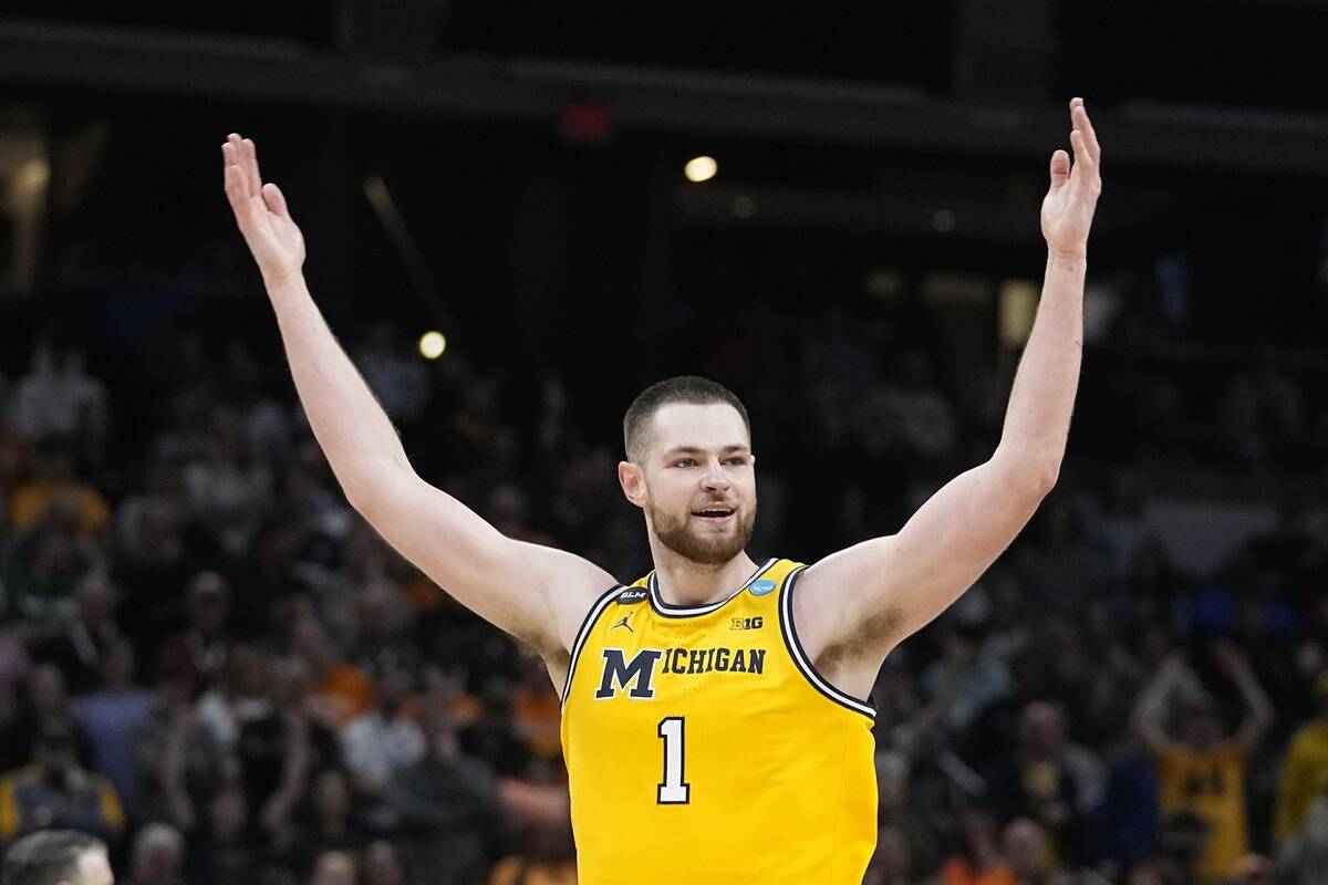 Michigan's Hunter Dickinson (1) celebrates after his team defeated Tennessee in a college baske ...