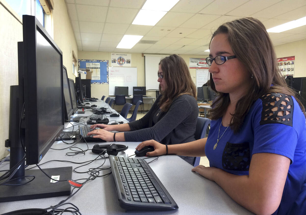 Leticia Fonseca, 16, left, and her twin sister, Sylvia Fonseca, work in the computer lab at Cuy ...