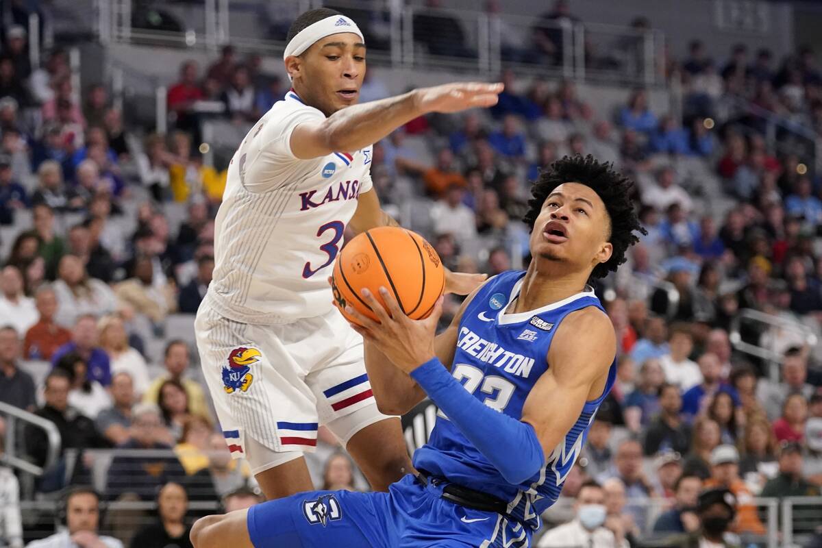 Kansas guard Dajuan Harris Jr. defends as Creighton guard Trey Alexander (23) attempts a shot i ...