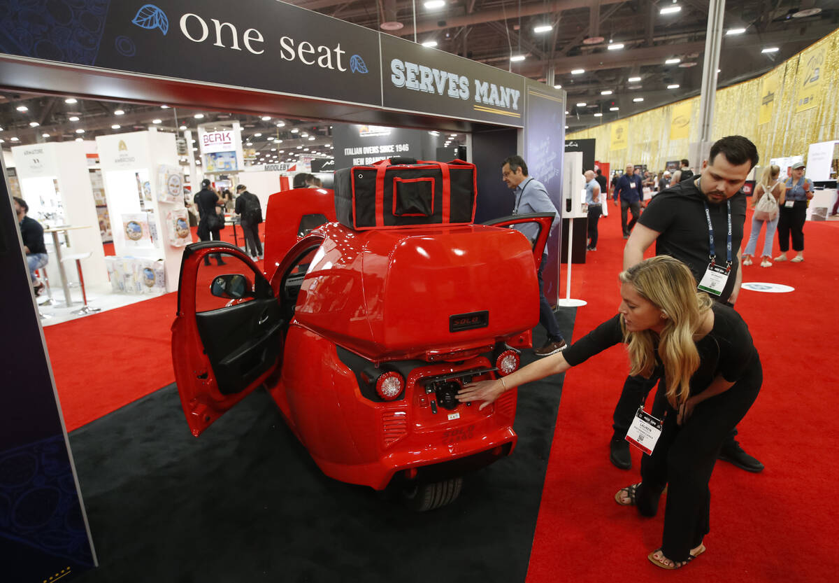 Lauren Iacoangelo, of ElectraMeccanica, points out to the charging port of the Solo electric ve ...