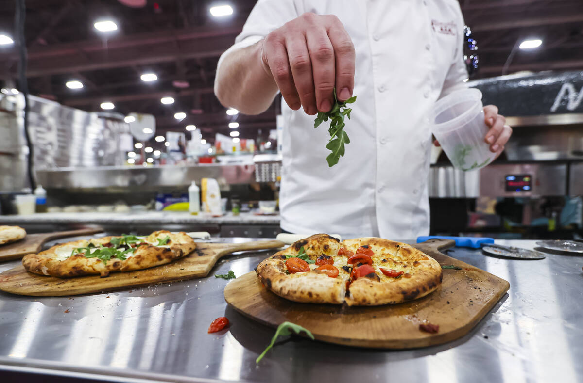 Pizza is prepared at the Marra Forni Brick Oven Cooking Solutions booth during the Internationa ...