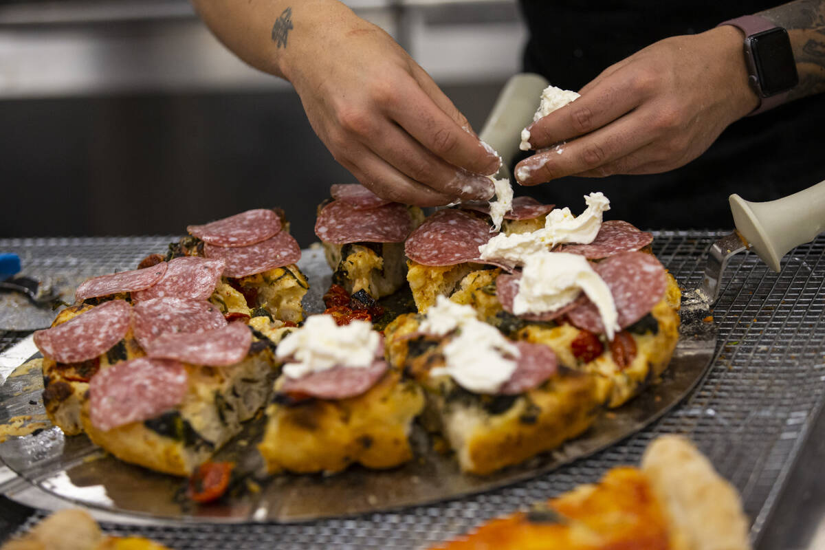 Chef Daniele Gagliotta prepares pizza at the Marra Forni Brick Oven Cooking Solutions booth dur ...