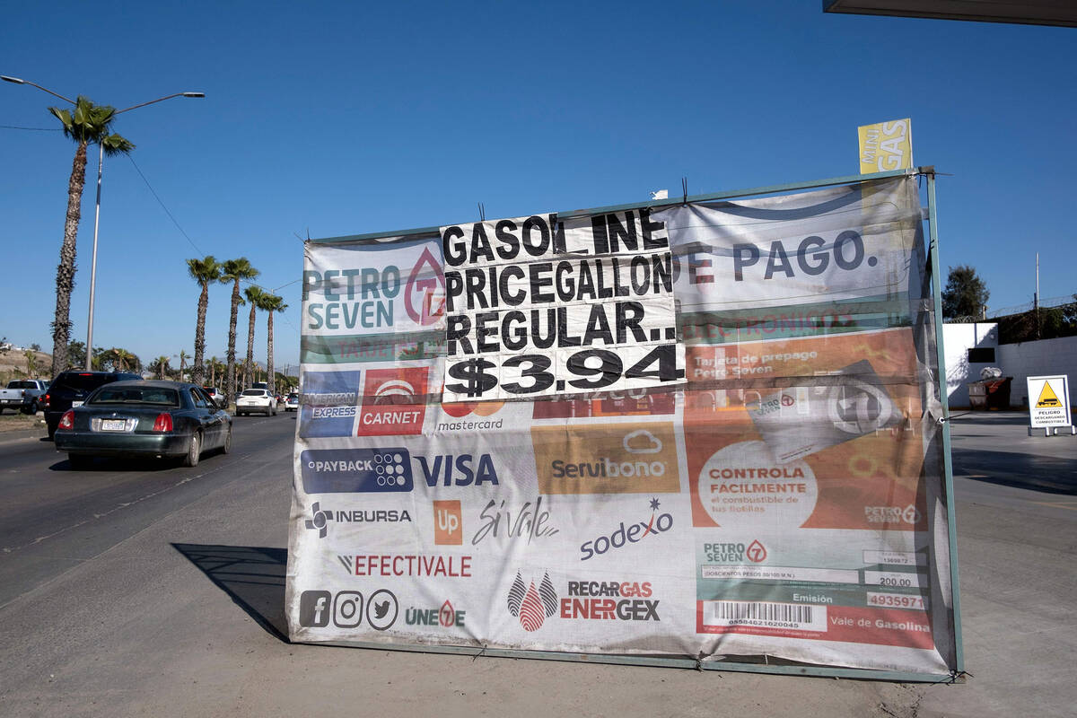 View of a sign advising commuters to fill their tanks before crossing to the US is displayed at ...