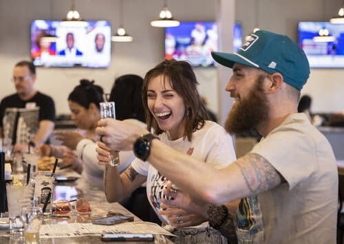 Liza Hunter, middle, and her husband Justin, celebrate opening day at Slaters 50/50 on March 23 ...