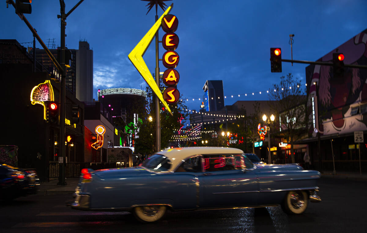 A 1954 Cadillac Coupe DeVille turns onto Fremont Street as rain falls on Monday, March 28, 2022 ...