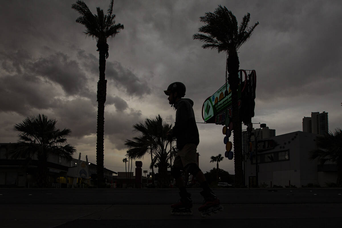 A man walking on Las Vegas Boulevard is silhouetted as clouds blanket the sky on Monday, March ...