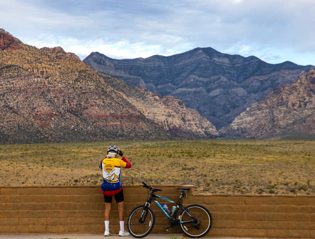 Rick Clennan of Las Vegas adjusts his helmet as he prepares to ride his bike after taking a bre ...