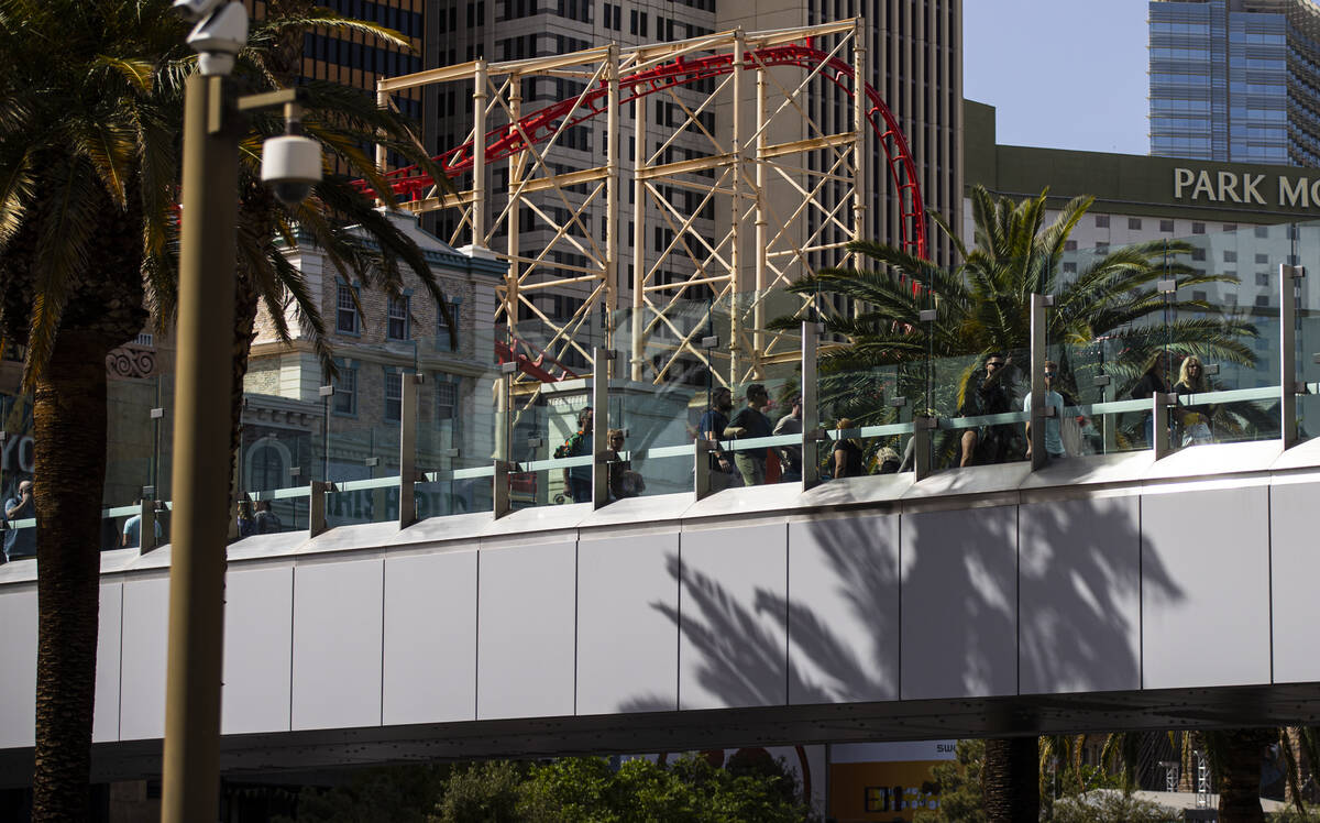 People walk along the pedestrian bridge where a man was killed by an assailant wielding a knife ...