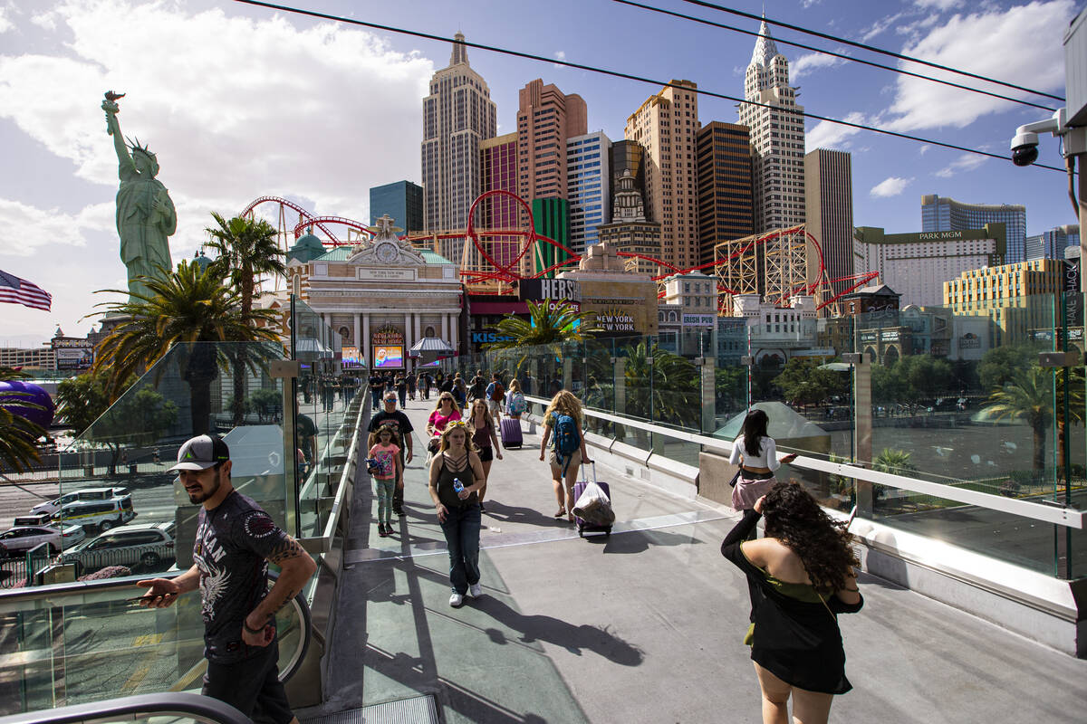 People walk along the pedestrian bridge where a man was killed by an assailant wielding a knife ...