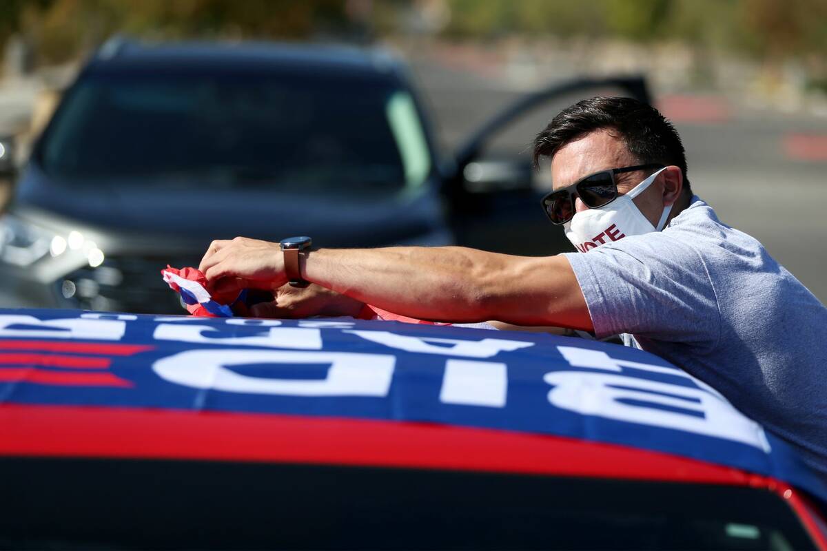 Matthew DeFalco, a U.S. Army veteran, decorates his car in preparations to the ballot drop off ...