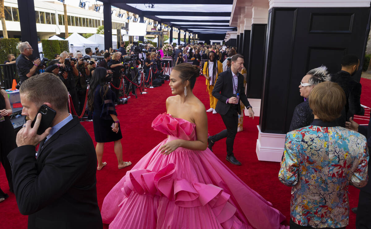 Chrissy Teigen, middle, on the red carpet before the start of the 2022 Grammy Awards on Sunday, ...