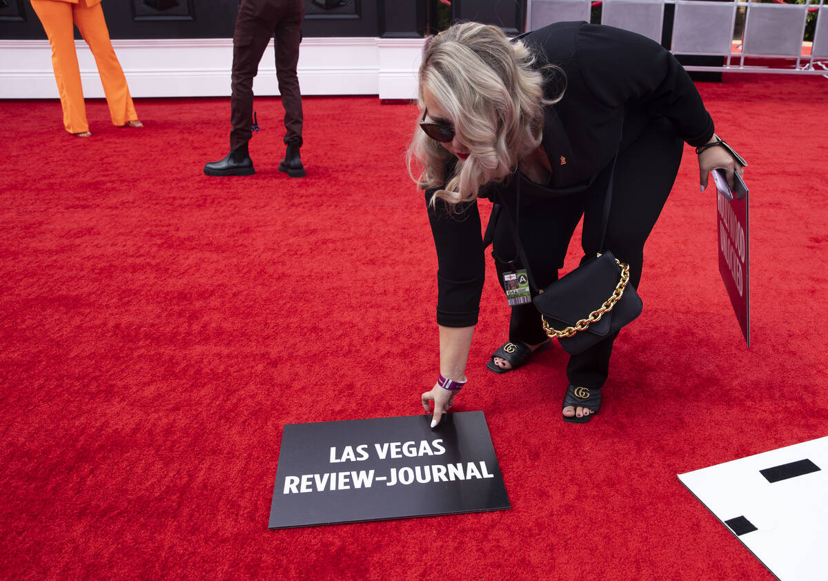 Staff label media outlets before the start of the red carpet for the 2022 Grammy Awards on Sund ...