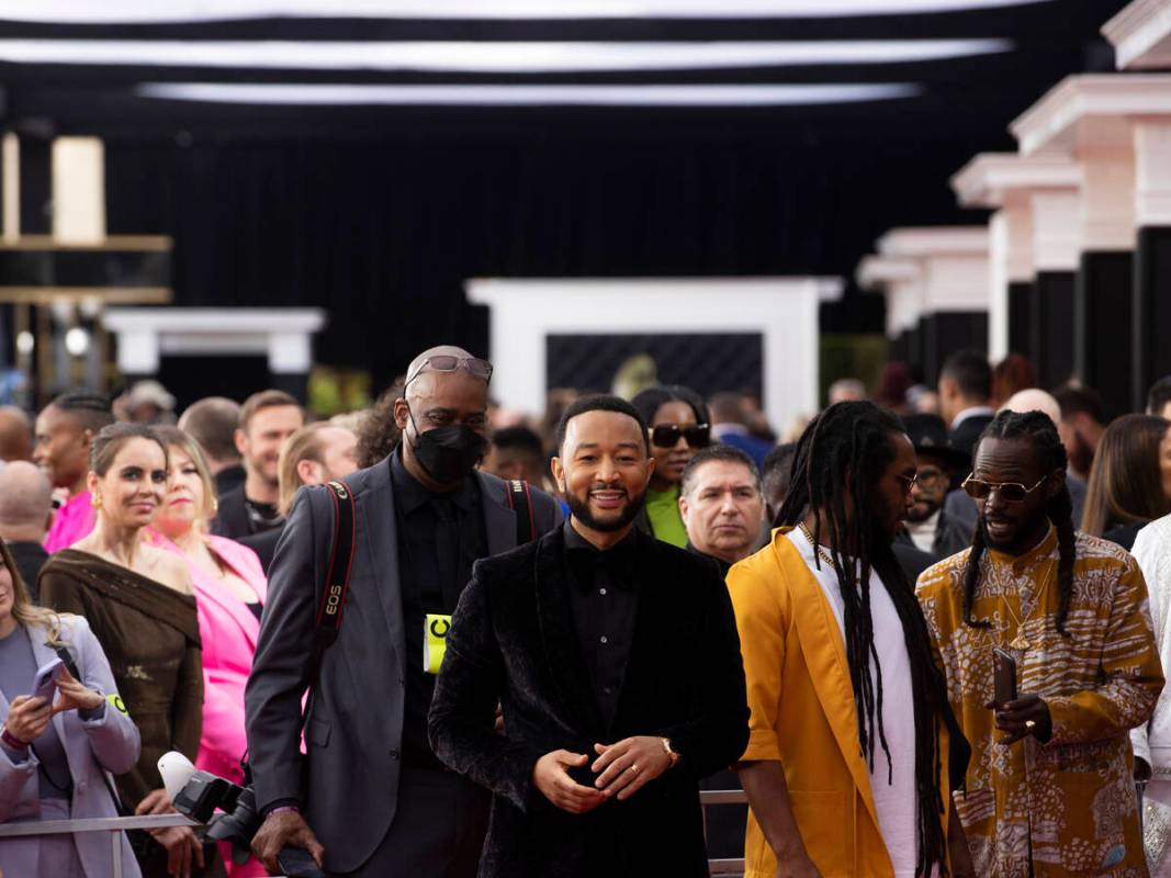 John Legend, middle, on the red carpet before the start of the 2022 Grammy Awards on Sunday, Ap ...