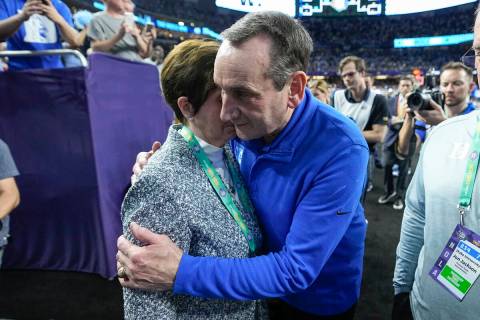 Duke head coach Mike Krzyzewski hugs his wife, Mickie, after Duke lost to North Carolina in a c ...