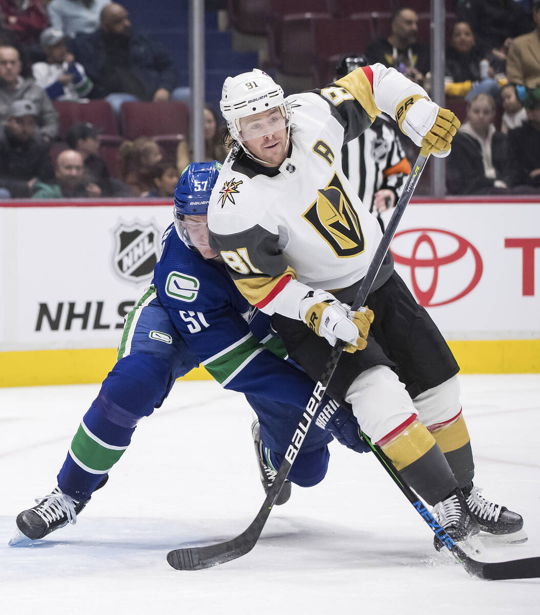 Vancouver Canucks' Tyler Myers, left, checks Vegas Golden Knights' Jonathan Marchessault during ...