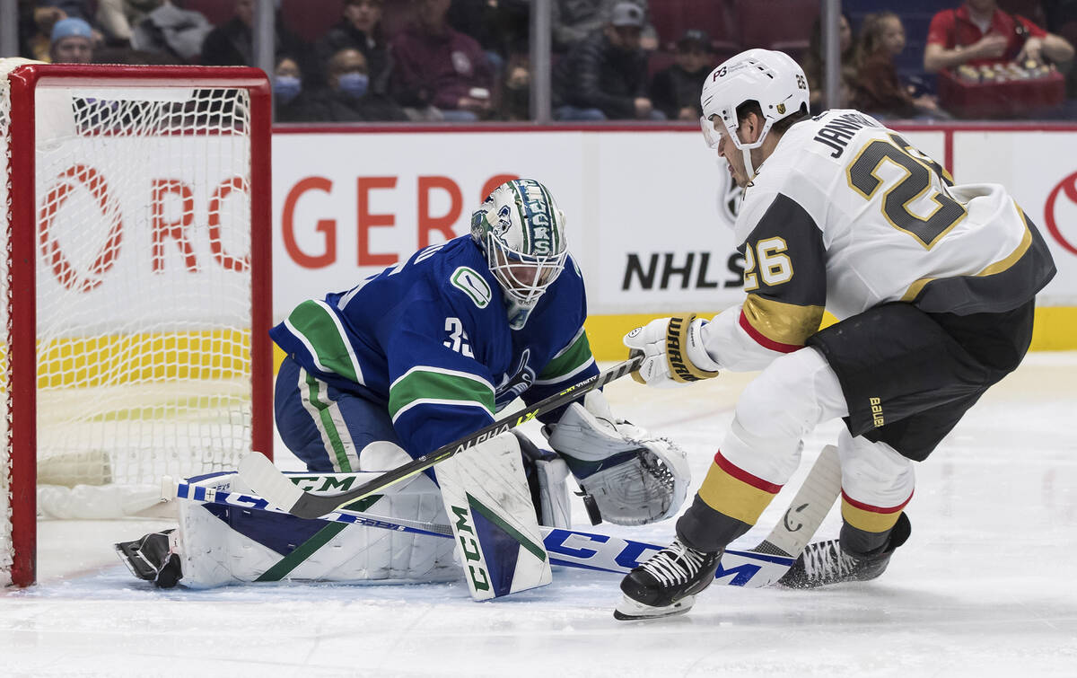 Vancouver Canucks goalie Thatcher Demko, left, stops Vegas Golden Knights' Mattias Janmark, of ...