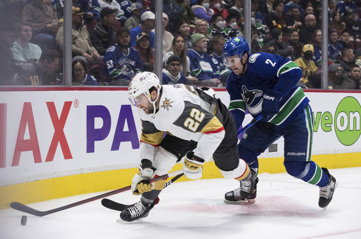 Vancouver Canucks' Luke Schenn, right, checks Vegas Golden Knights' Michael Amadio during the s ...