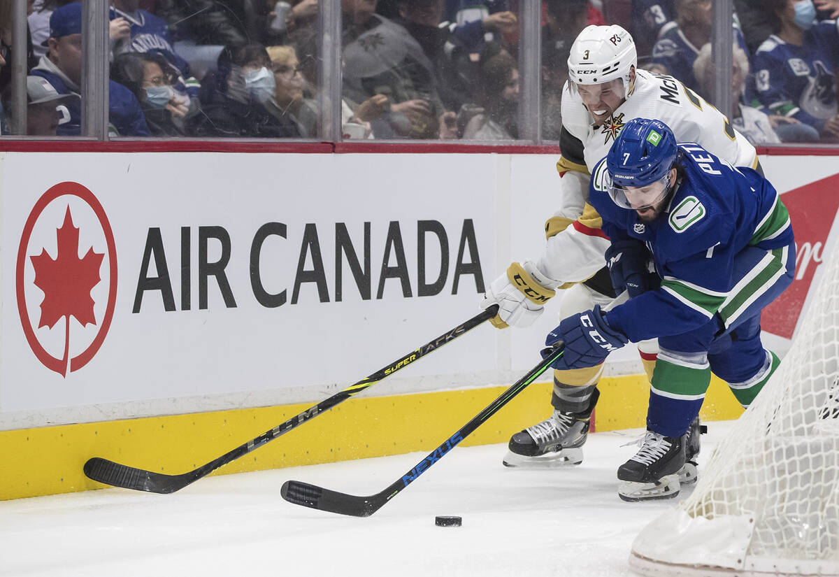 Vegas Golden Knights' Brayden McNabb (3) checks Vancouver Canucks' Nic Petan (7) during the fir ...