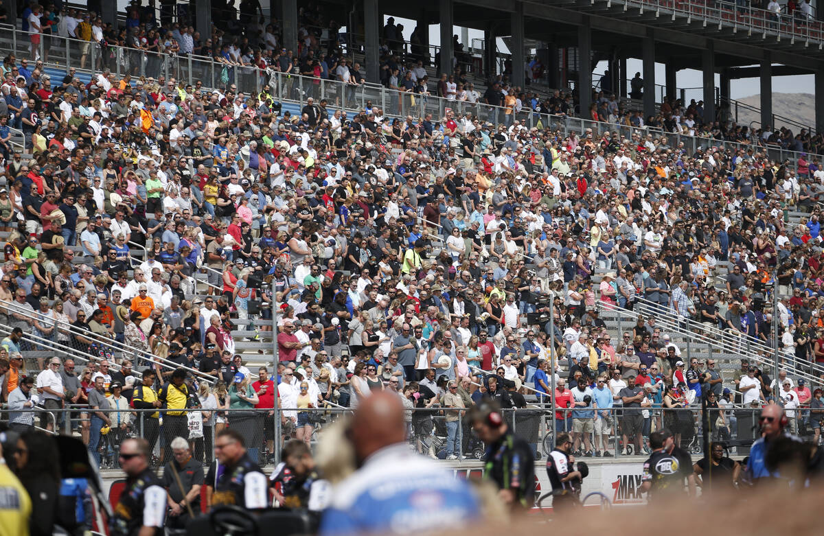 Attendees stand for the national anthem before the start of the NHRA Four-Wide Nationals at The ...