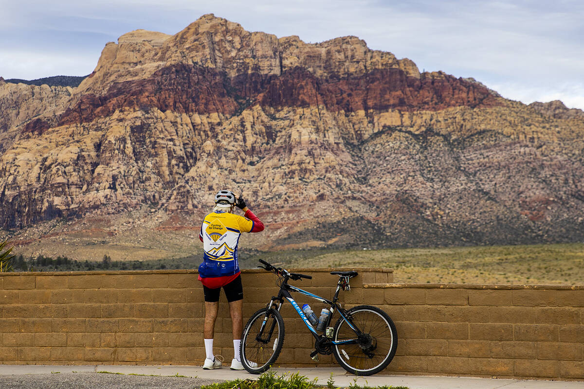 Rick Clennan of Las Vegas adjusts his helmet as he prepares to ride his bike after taking a bre ...