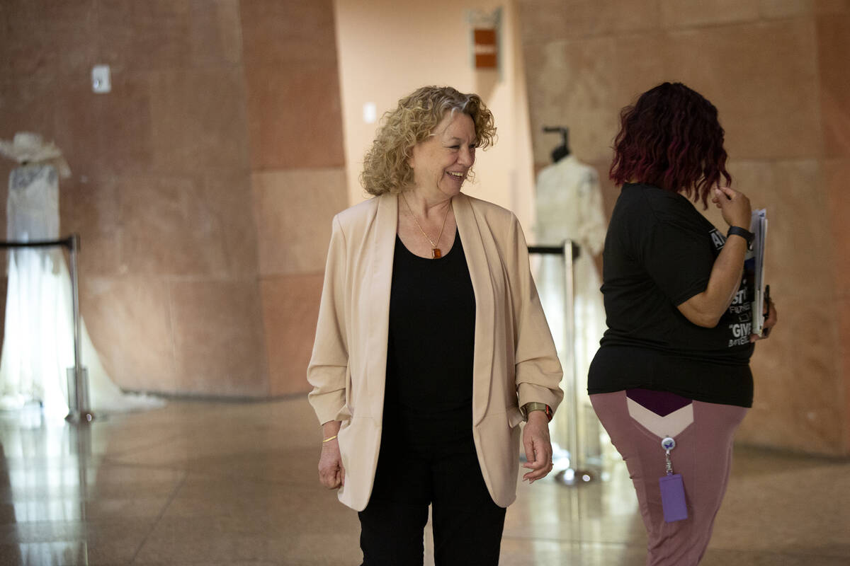 Clark County Clerk Lynn Goya, center, views wedding dresses on display in a historical wedding ...