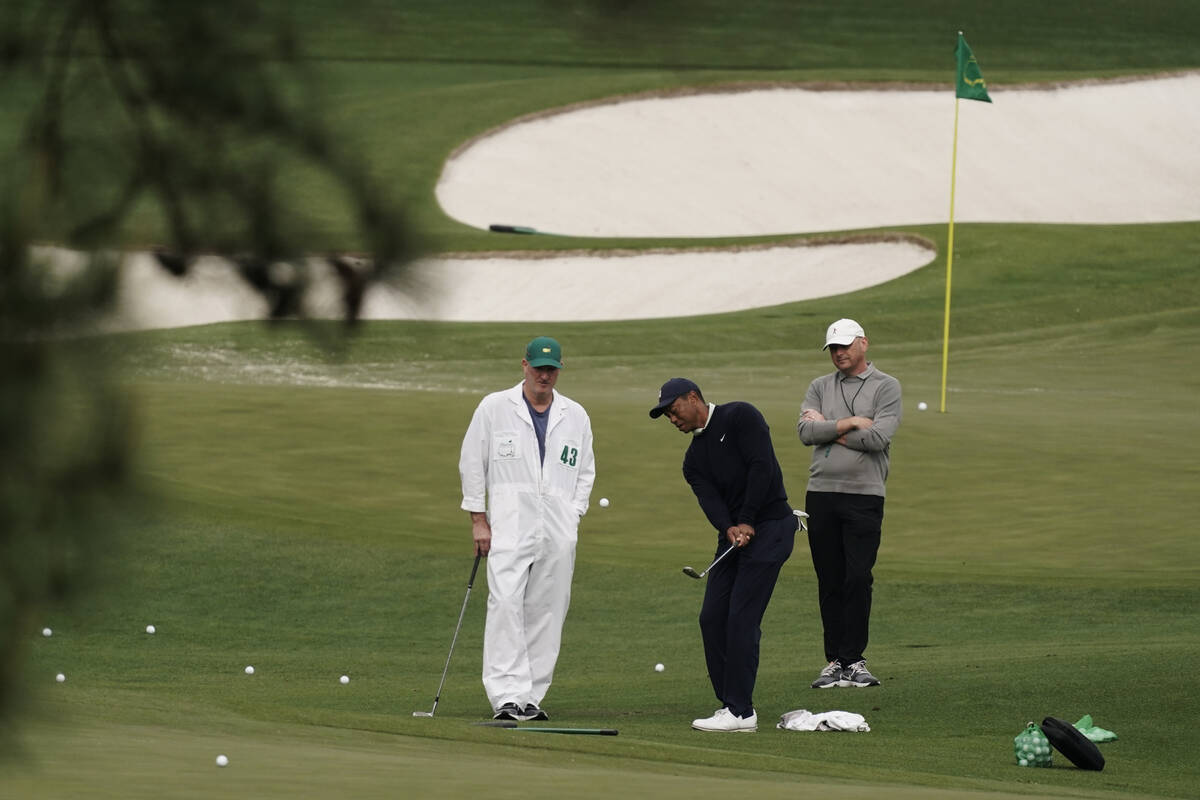 Tiger Woods hits on the driving range during a practice round for the Masters golf tournament o ...
