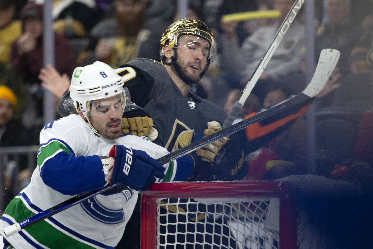 Golden Knights center Nicolas Roy (10) fights with Canucks right wing Conor Garland (8) during ...