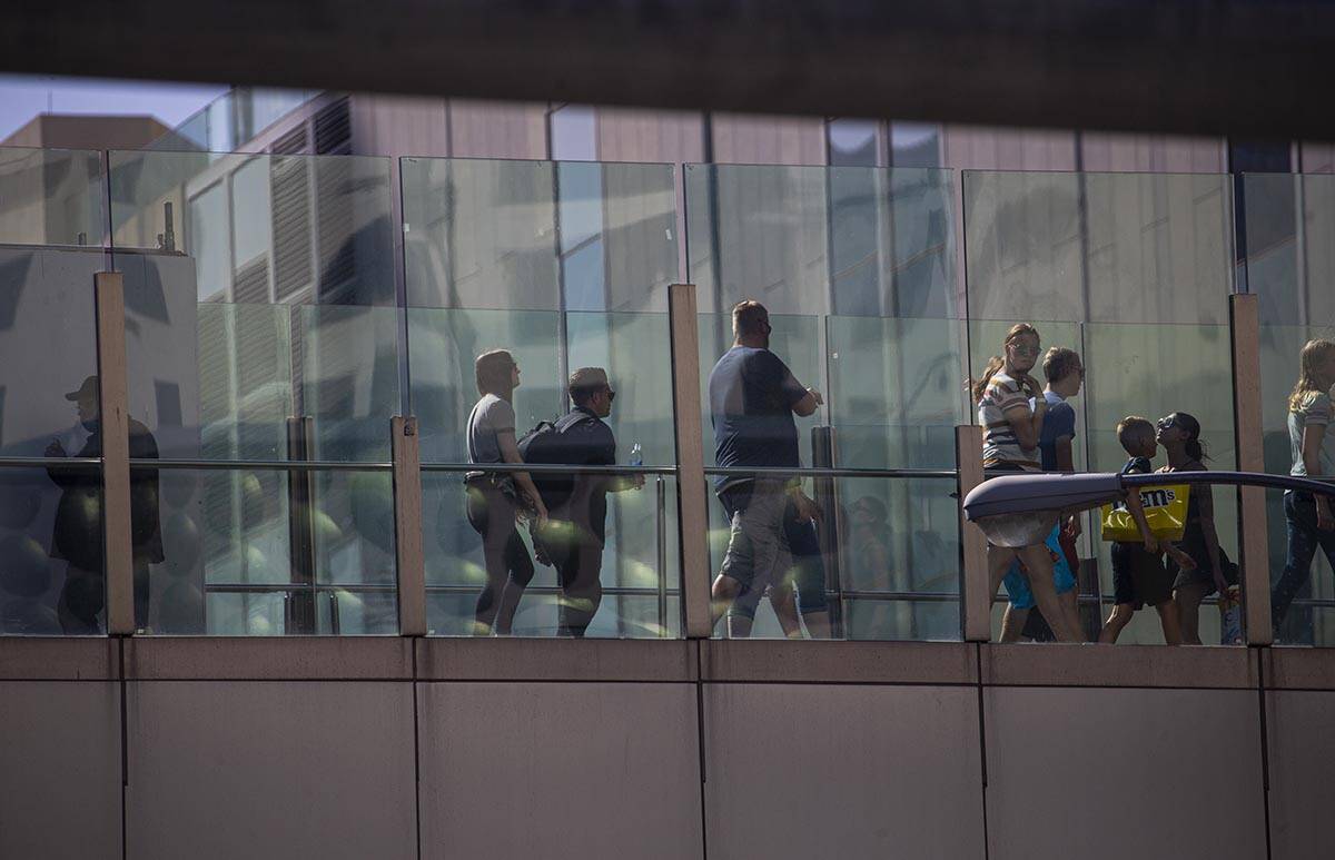 Pedestrians cross a bridge along the Las Vegas Strip on Wednesday, April 6, 2022, in Las Vegas. ...