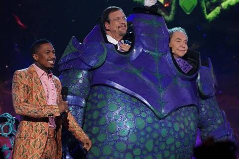 "The Masked Singer" host Nick Cannon is shown with Penn & Teller after being eliminated and unm ...